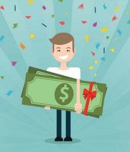 Young brunette guy really happy enjoying and holding huge gift pack of green money/dollars with both hands. Win in a lottery concept